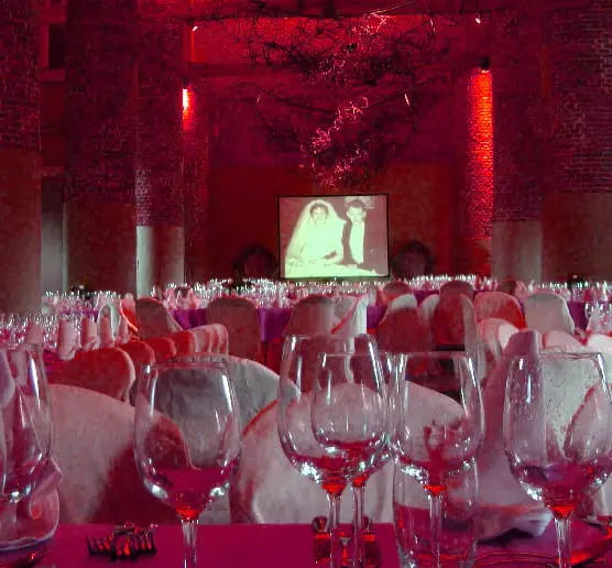 Projection vidéo sur écran dans une salle de réception aux tables dressées