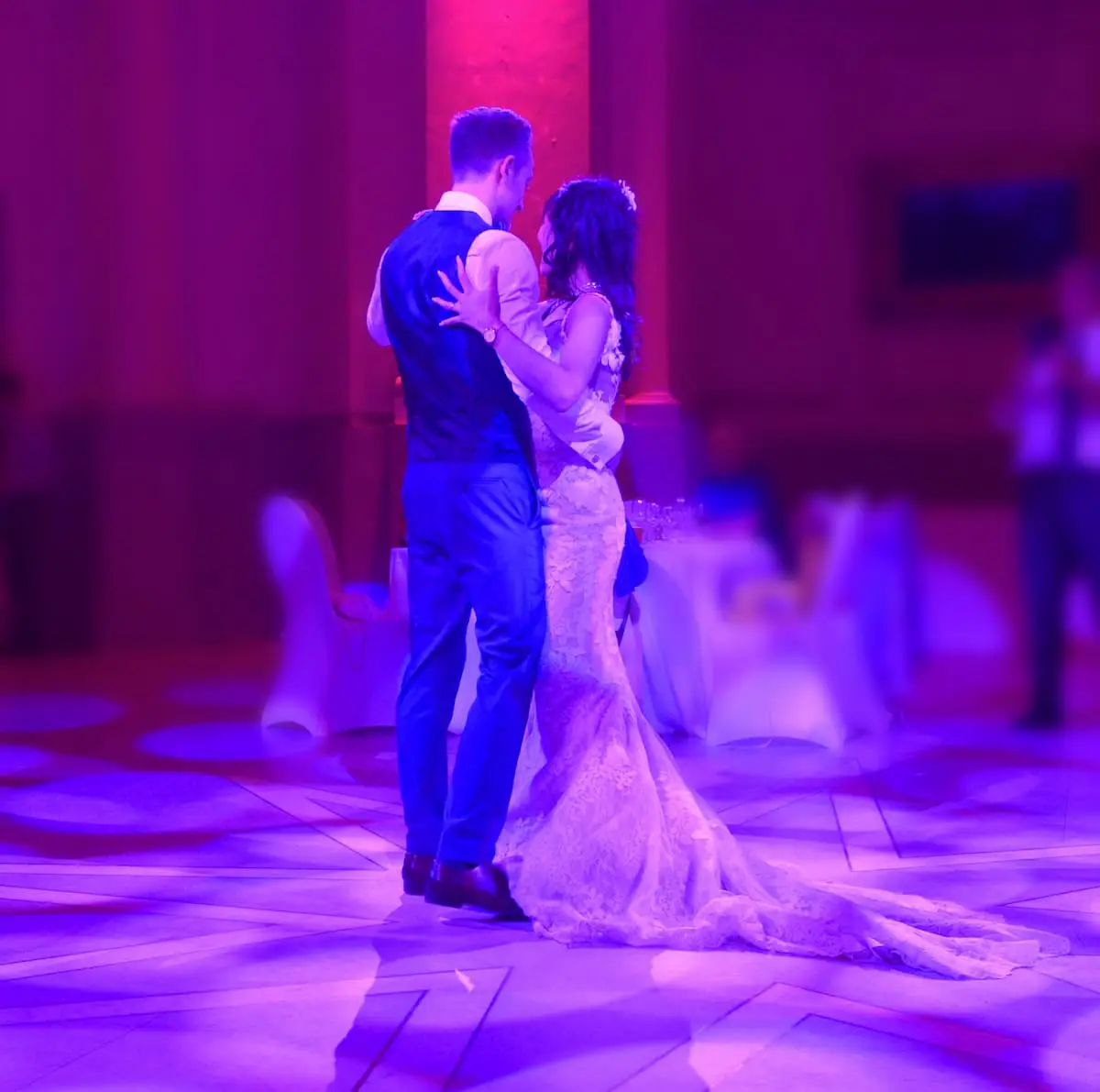 Mariés dansant leur ouverture de bal sous une lumière violette